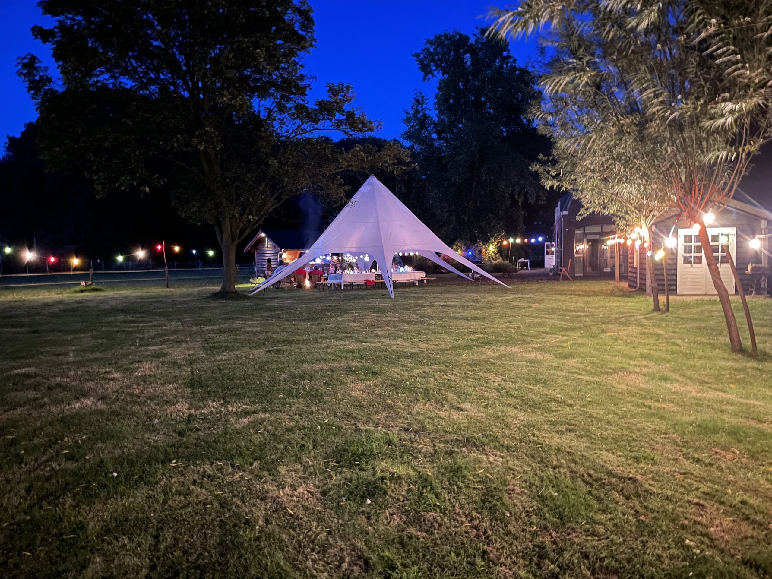 Sfeervol avond diner buiten onder een verlichte stertent